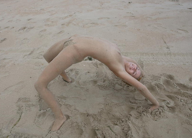 Стройная молодая девица голая позирует на пляже 15 фото